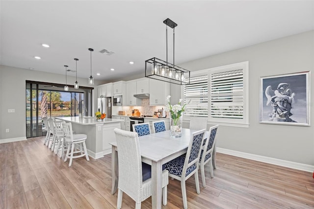 dining area featuring sink and light hardwood / wood-style flooring