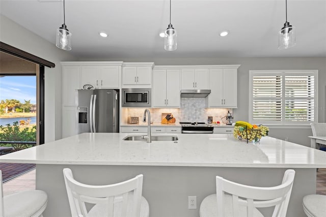 kitchen with white cabinetry, sink, stainless steel appliances, and decorative light fixtures