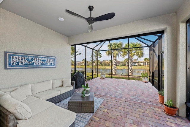 view of patio / terrace featuring outdoor lounge area, a water view, and glass enclosure