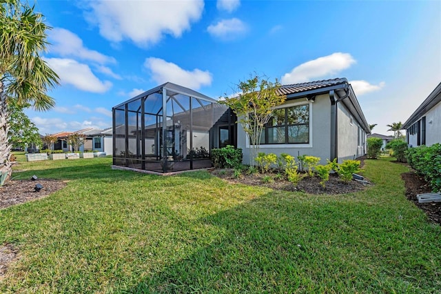 back of house with a lanai and a lawn