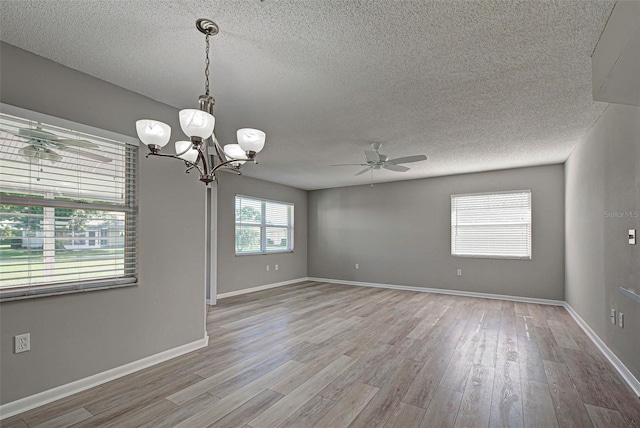 unfurnished room featuring ceiling fan with notable chandelier, a textured ceiling, and light hardwood / wood-style flooring