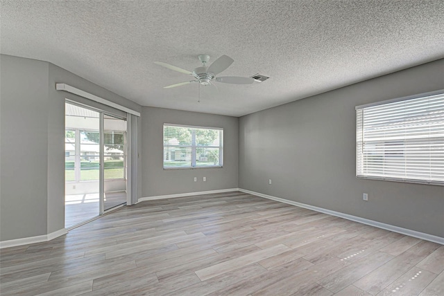 spare room featuring a textured ceiling, ceiling fan, and light wood-type flooring