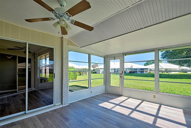 unfurnished sunroom with ceiling fan and vaulted ceiling