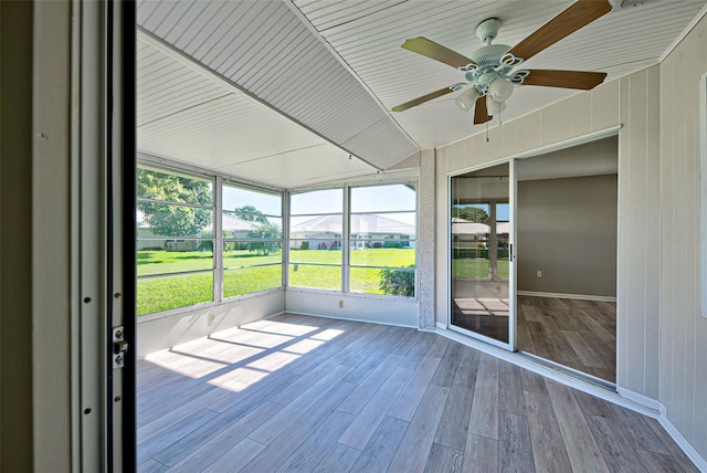 unfurnished sunroom with ceiling fan