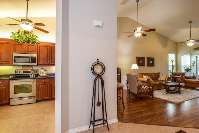 kitchen featuring light tile patterned flooring, lofted ceiling, and appliances with stainless steel finishes