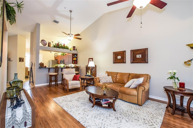 living room with high vaulted ceiling, ceiling fan, and dark wood-type flooring