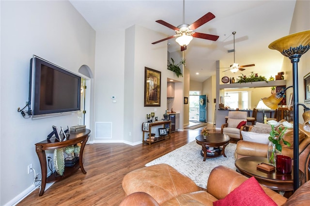 living room featuring high vaulted ceiling, ceiling fan, and dark wood-type flooring