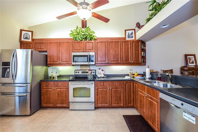 kitchen featuring ceiling fan, sink, stainless steel appliances, lofted ceiling, and light tile patterned floors