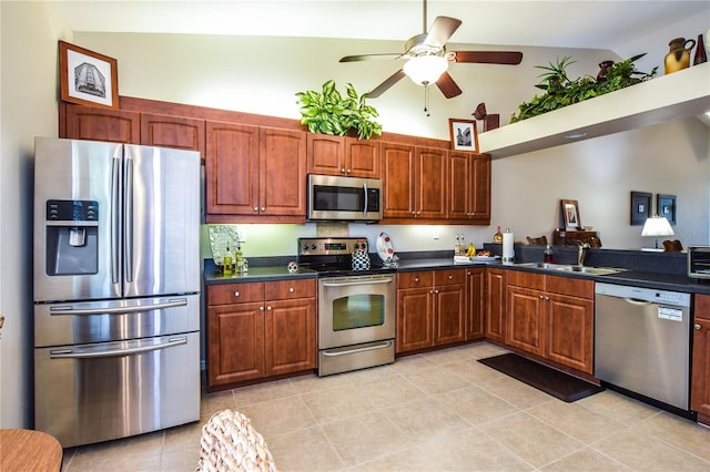 kitchen featuring lofted ceiling, sink, ceiling fan, appliances with stainless steel finishes, and light tile patterned flooring