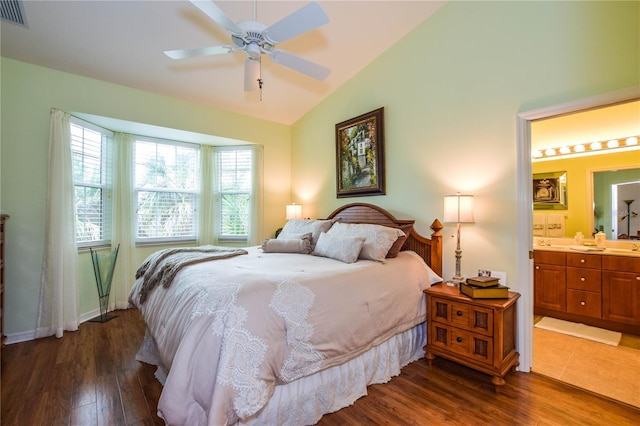 bedroom with ensuite bathroom, vaulted ceiling, ceiling fan, and dark wood-type flooring