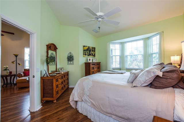 bedroom featuring ceiling fan, vaulted ceiling, dark wood-type flooring, and multiple windows