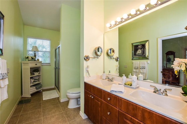 bathroom featuring tile patterned floors, a shower with door, vanity, and toilet