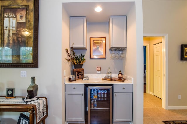 bar with gray cabinets, light tile patterned floors, and wine cooler