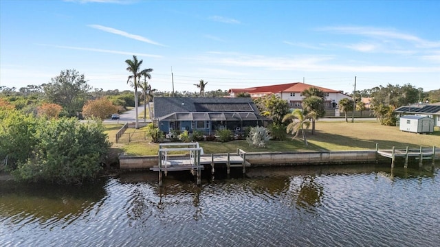 view of dock with a yard, a water view, and glass enclosure