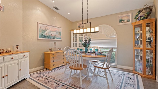 dining room featuring vaulted ceiling and wood-type flooring