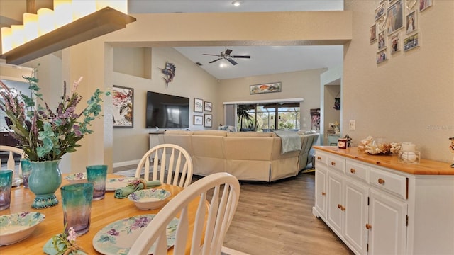 dining space featuring lofted ceiling, ceiling fan, and light wood-type flooring