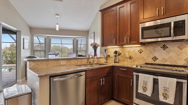 kitchen featuring kitchen peninsula, stainless steel appliances, light stone countertops, and sink