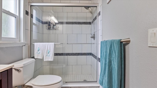 bathroom featuring toilet, vanity, and walk in shower