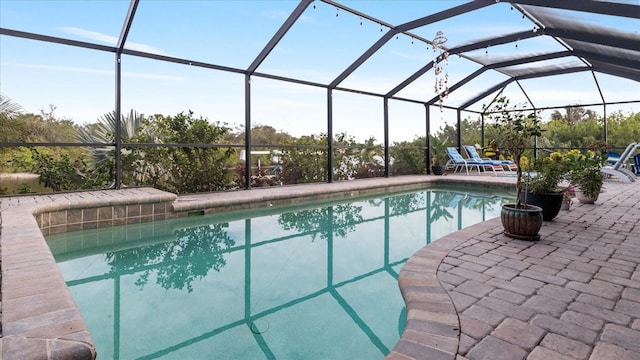 view of pool featuring glass enclosure and a patio