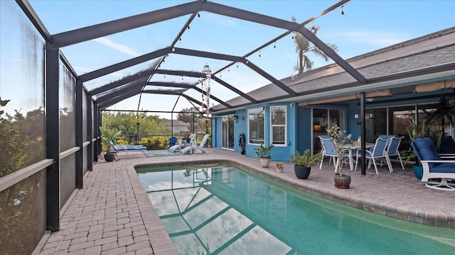 view of swimming pool featuring a patio and glass enclosure