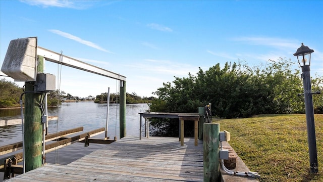 dock area with a yard and a water view