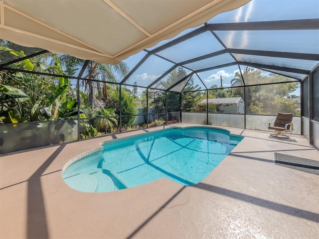 view of swimming pool featuring a patio area and glass enclosure