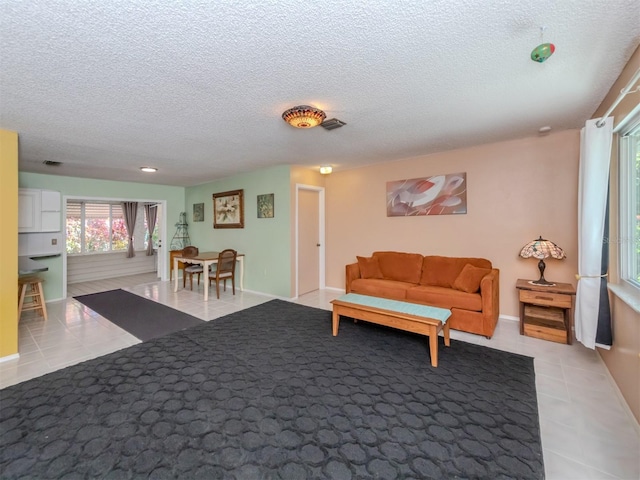 living room with a textured ceiling and light tile patterned floors