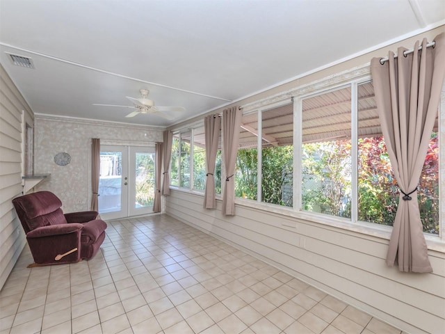 unfurnished sunroom featuring ceiling fan and french doors