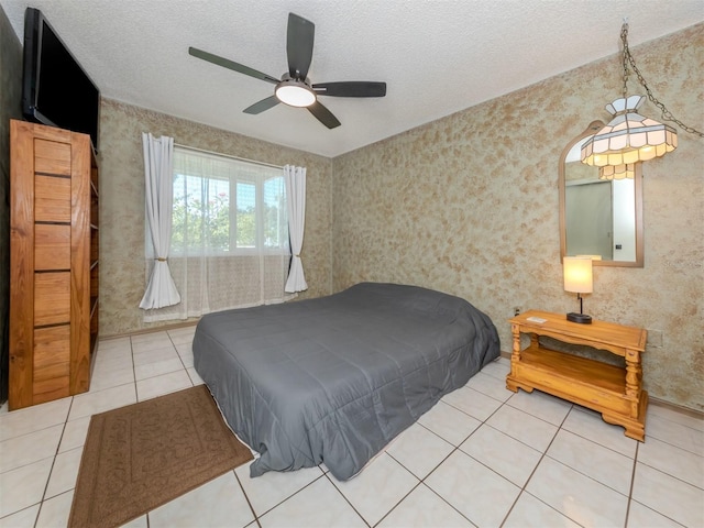 bedroom featuring a textured ceiling, ceiling fan, and light tile patterned floors