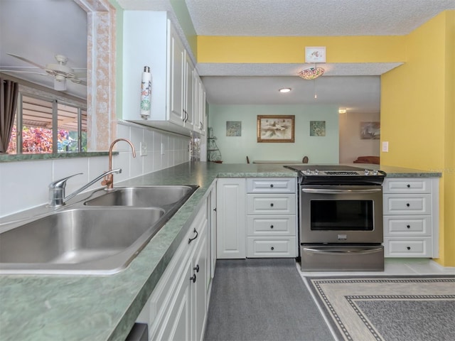 kitchen featuring white cabinets, a textured ceiling, sink, stainless steel range with electric cooktop, and tasteful backsplash