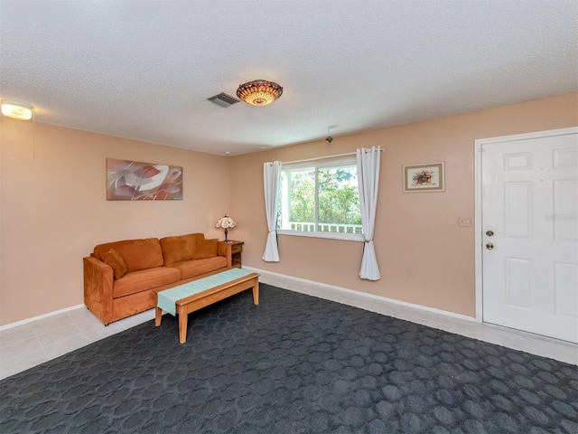 tiled living room featuring a textured ceiling