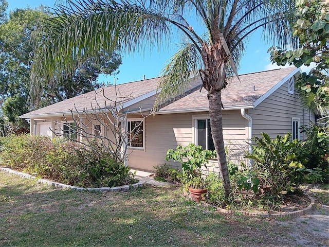 view of side of home featuring a garage and a yard