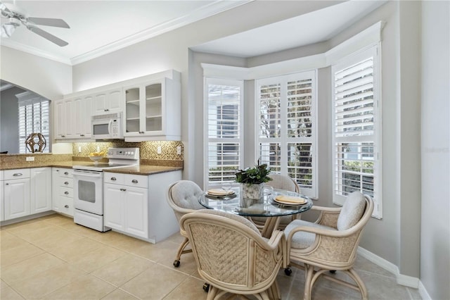 kitchen featuring light tile patterned flooring, white cabinetry, ornamental molding, white appliances, and backsplash