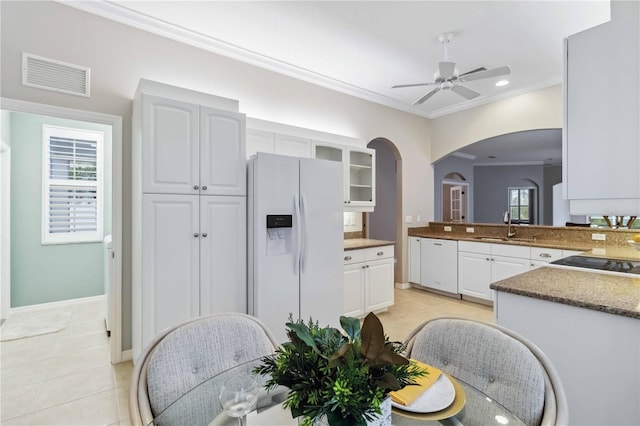 kitchen featuring light tile patterned flooring, white appliances, ornamental molding, and white cabinets