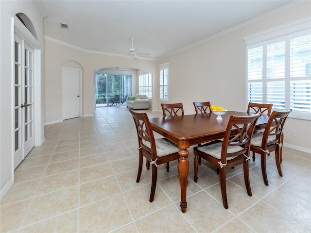 tiled dining area featuring crown molding and ceiling fan