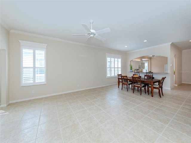 tiled dining room featuring crown molding and ceiling fan