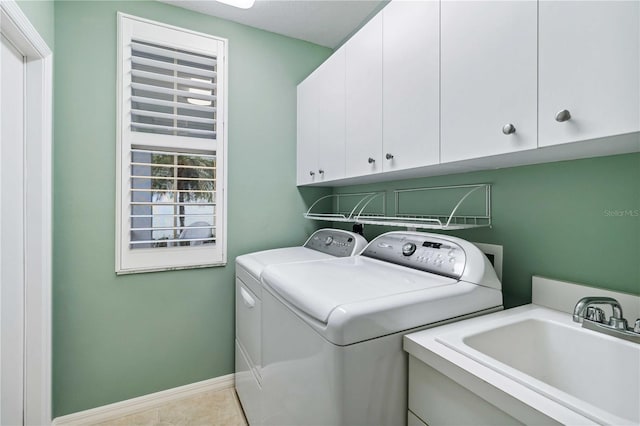 laundry area featuring cabinets, light tile patterned flooring, sink, and washer and clothes dryer