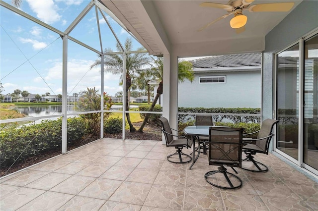 sunroom with a water view and ceiling fan