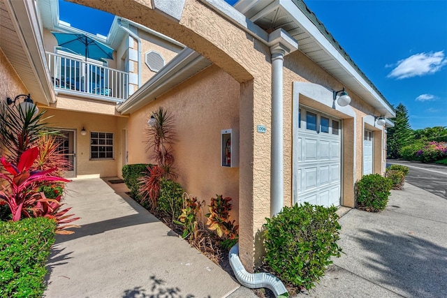 doorway to property with a balcony and a garage