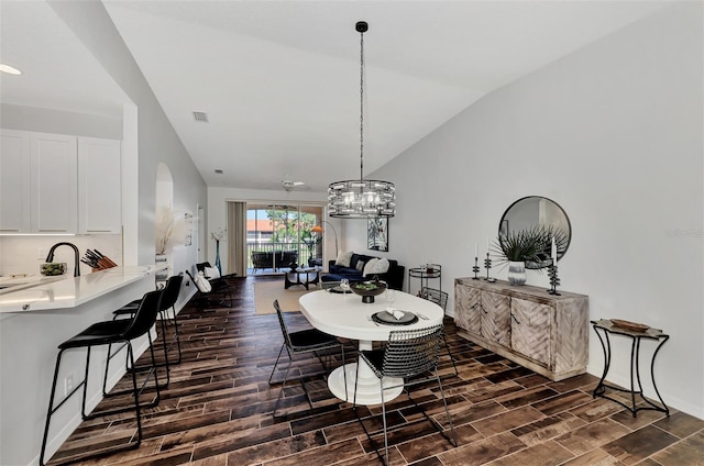 dining room with ceiling fan, lofted ceiling, and sink