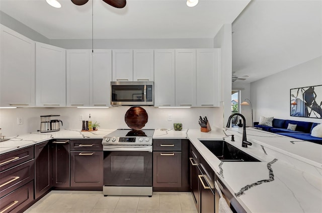 kitchen featuring sink, stainless steel appliances, white cabinetry, and light stone countertops