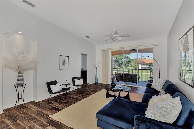 living room with dark wood-type flooring, ceiling fan, and vaulted ceiling