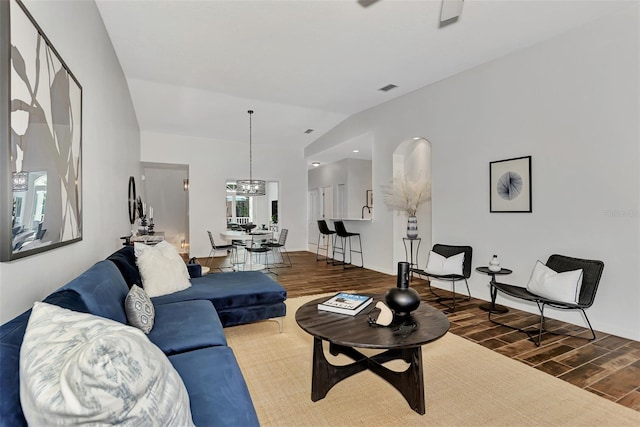 living room with a notable chandelier and vaulted ceiling