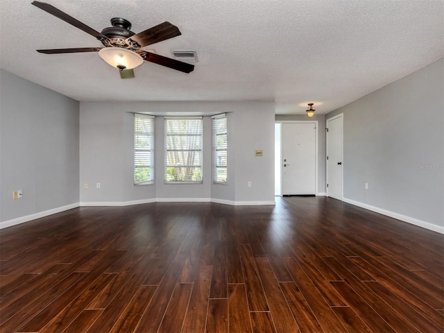 unfurnished living room featuring a textured ceiling, ceiling fan, and dark hardwood / wood-style floors