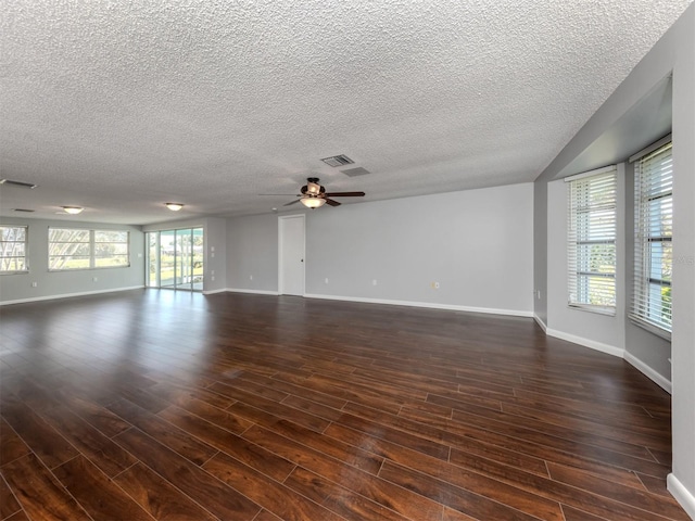 spare room with ceiling fan, dark wood-type flooring, and a textured ceiling