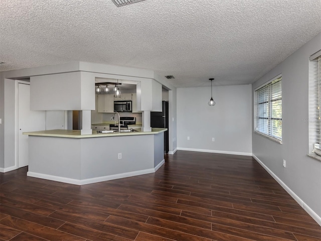 kitchen with decorative light fixtures, sink, a textured ceiling, and kitchen peninsula