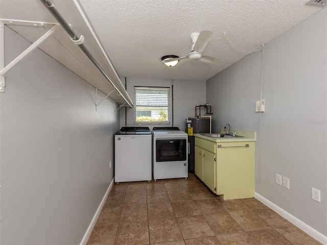 laundry room with ceiling fan, washer and dryer, sink, a textured ceiling, and cabinets