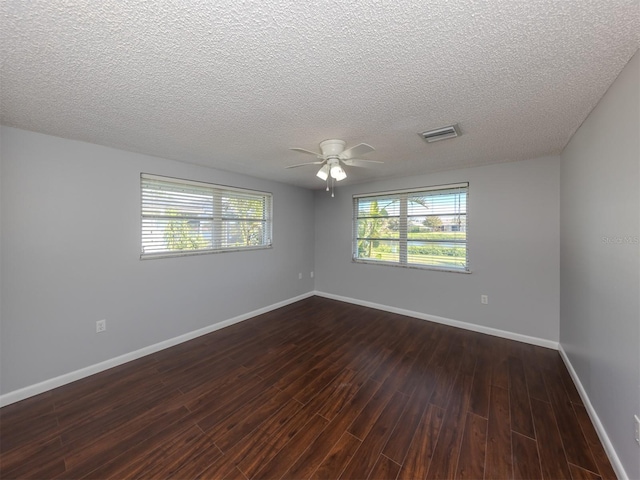 empty room featuring a textured ceiling, ceiling fan, and dark hardwood / wood-style flooring