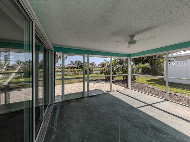 unfurnished sunroom featuring ceiling fan