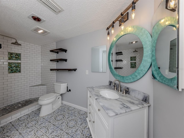 bathroom featuring a textured ceiling, tile patterned floors, vanity, and toilet